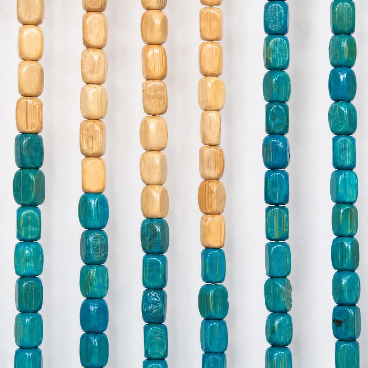 Gros plan sur une perle en bois beige et turquoise