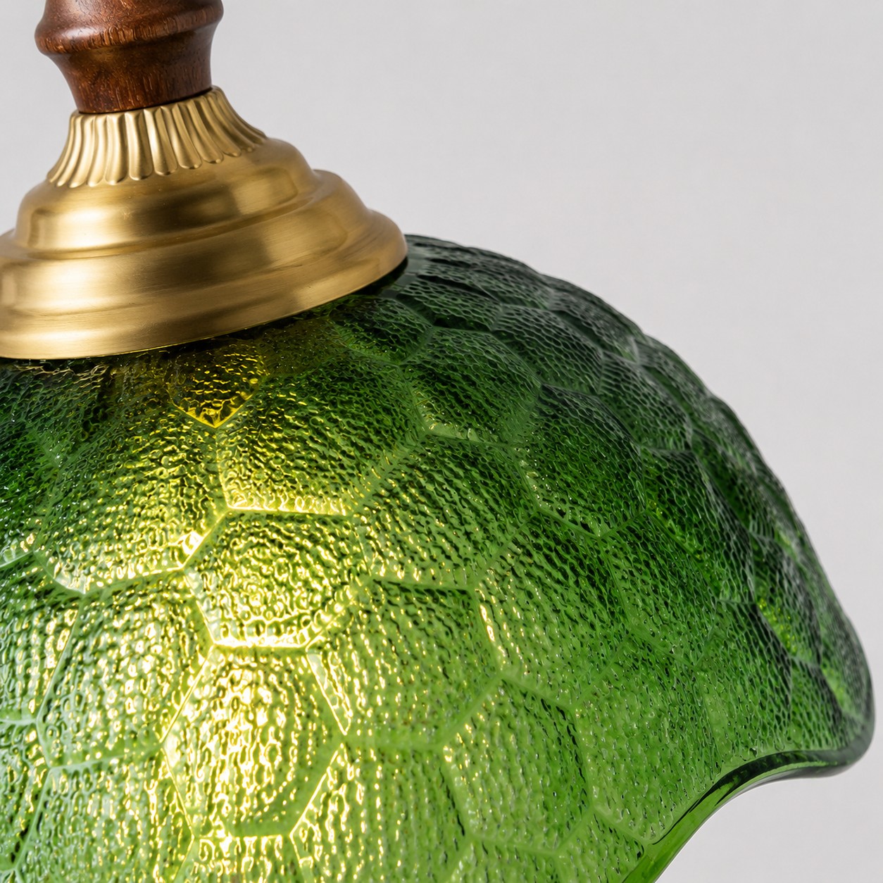 Gros plan sur un verre pressé vert et un bouchon couleur laiton
